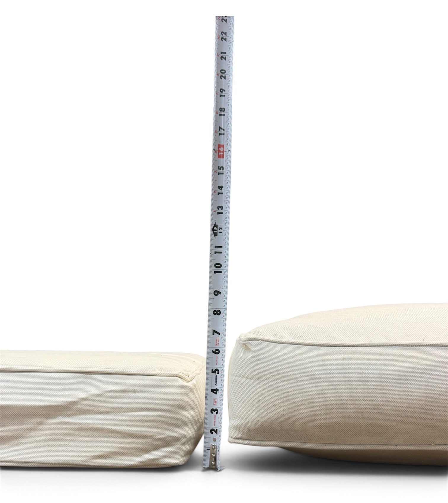 Two sofa seat cushions with a tape measure showing the lift a Cushion Booster adds